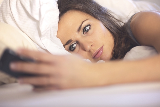 Woman Reading Phone in Bed