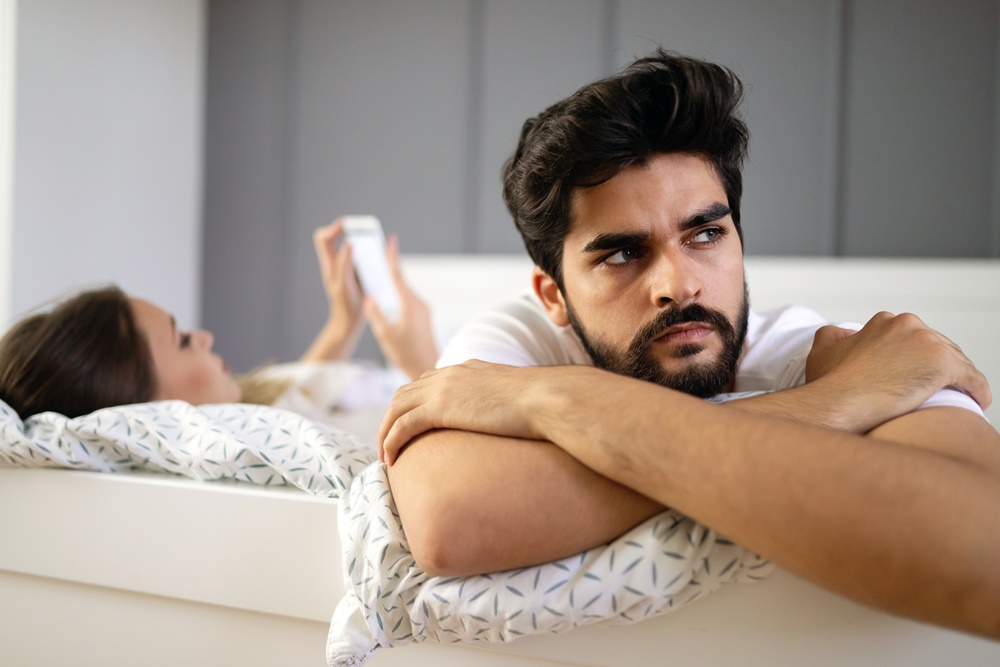 Frustrated Husband in Bed with Wife Ignoring Him